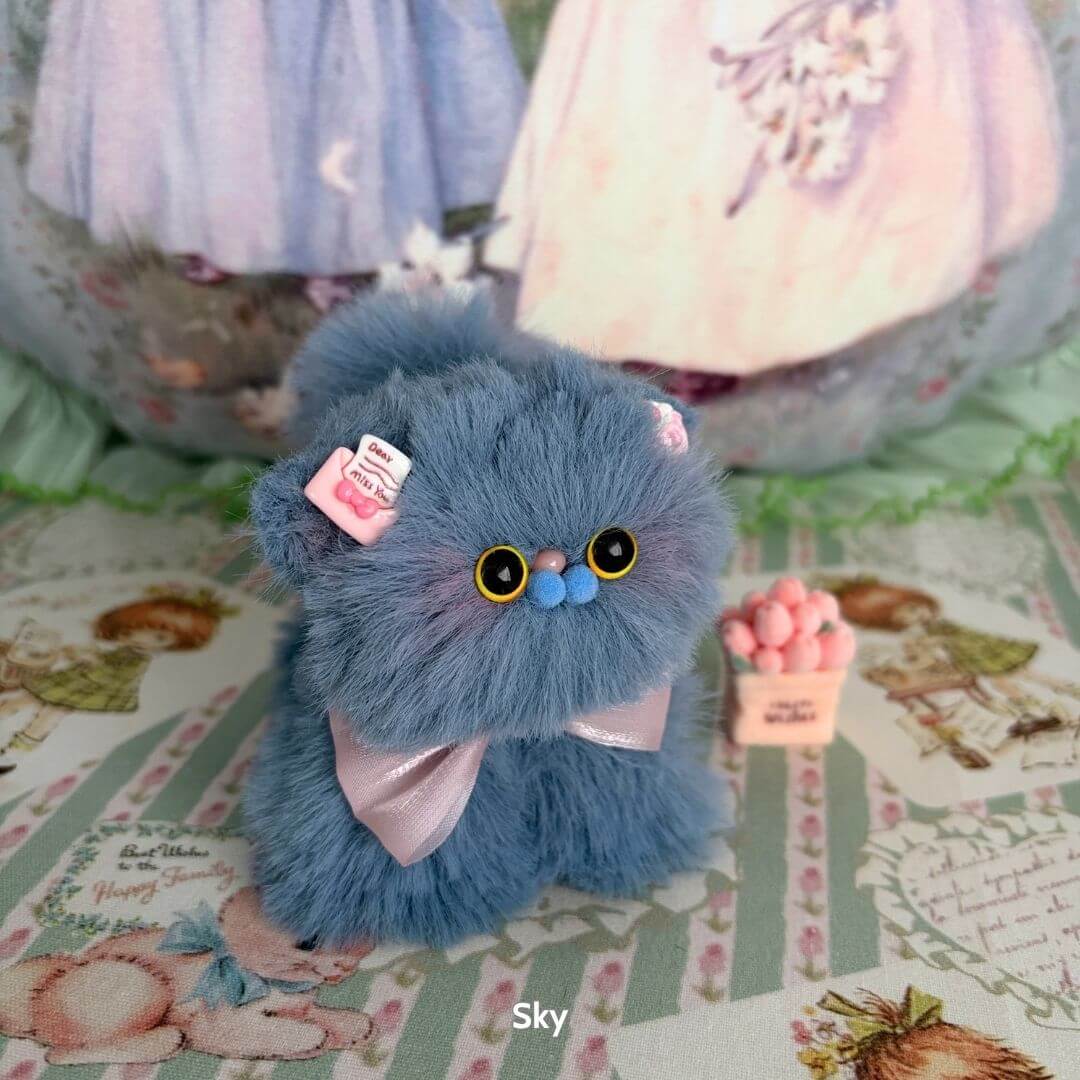 A fluffy blue kitten figurine from the Fluffy Kitten Collection, adorned with a bow and holding a pink milk carton, cute collectible.