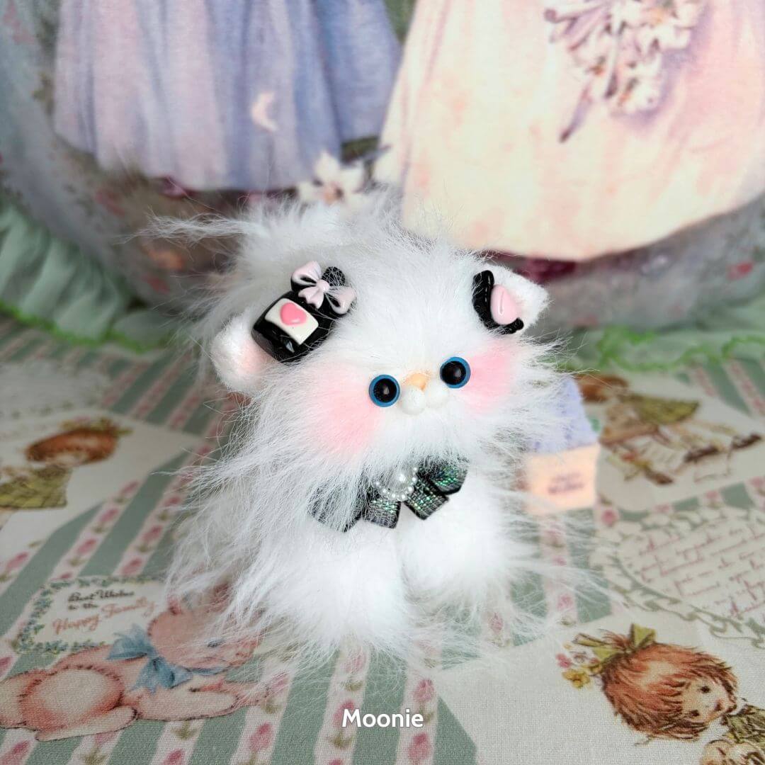 Cute fluffy cat figurine from Siberian Snuggles Collection, featuring pastel colors, decorated with bows and playful expression.