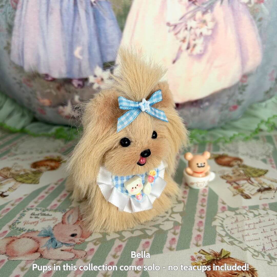 Fluffy Puppy Collection - Handmade fluffy toy dog Bella with blue bow and collar, sitting amidst a charming patterned background.