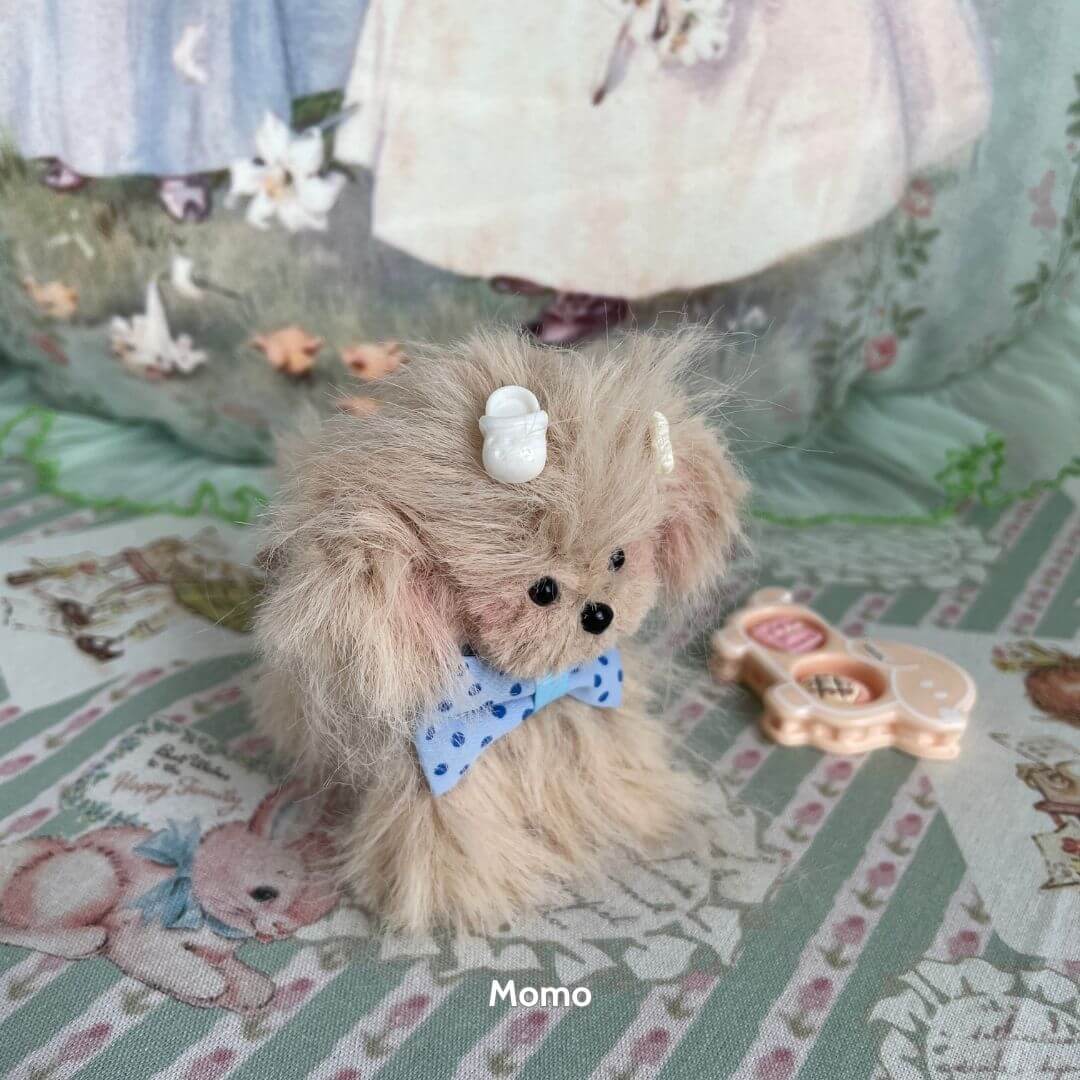 Fluffy Puppy Collection handmade toy dog with fluffy beige fur, blue bow, and dessert-themed accessories, showcasing a cute collectible style.