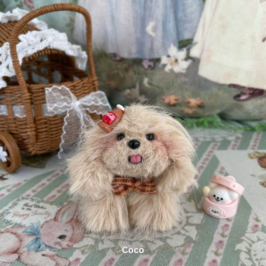 Handmade plush toy puppy with brown bow and dessert-themed accessory, sitting beside a wicker basket, part of Fluffy Puppy Collection.