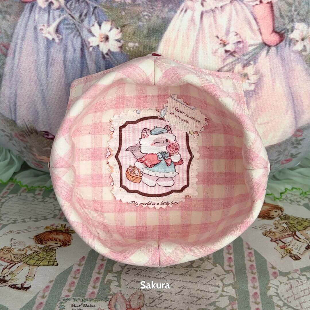 Gingham Cat Catch-All Tray featuring pastel pink gingham and an adorable kitten holding a treat inside a charming design.