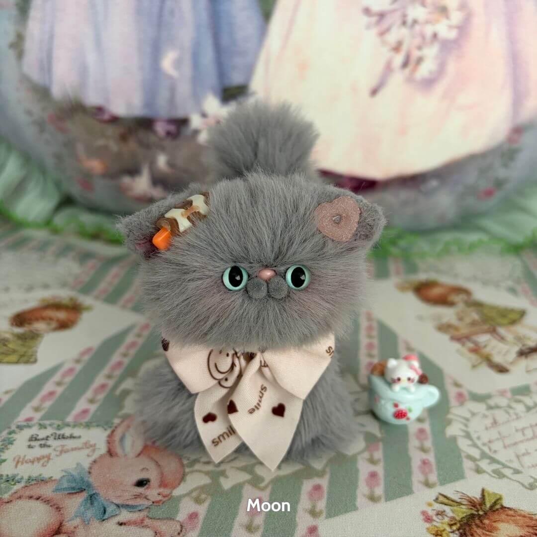 Grey Kitten Collection: fluffy grey kitten with teal eyes, wearing a bow and playful accessories, handmade in UK.