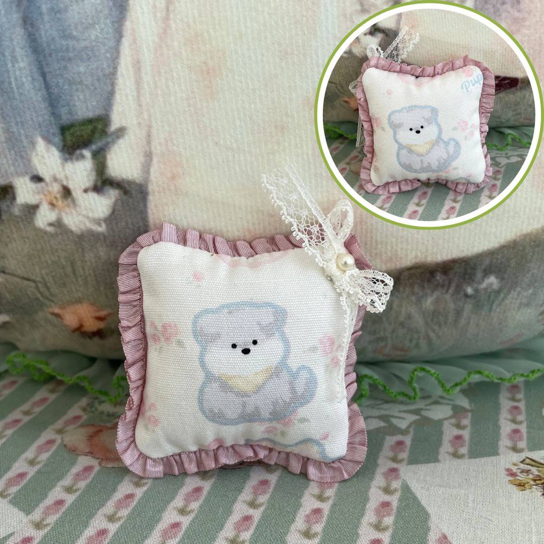 Handmade tiny cuddle critter cushions with a bear design, featuring hand-stitched bow, ideal for dolls or decor; size 6cm x 6cm.