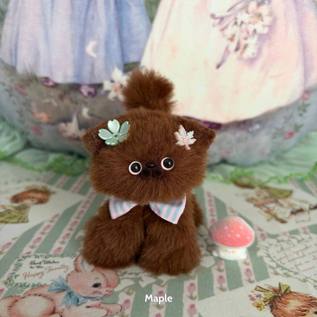 Brown Kitten Collection: kawaii fluffy brown kitten figurine with mint flower and pink bow, surrounded by cute pastel decor.