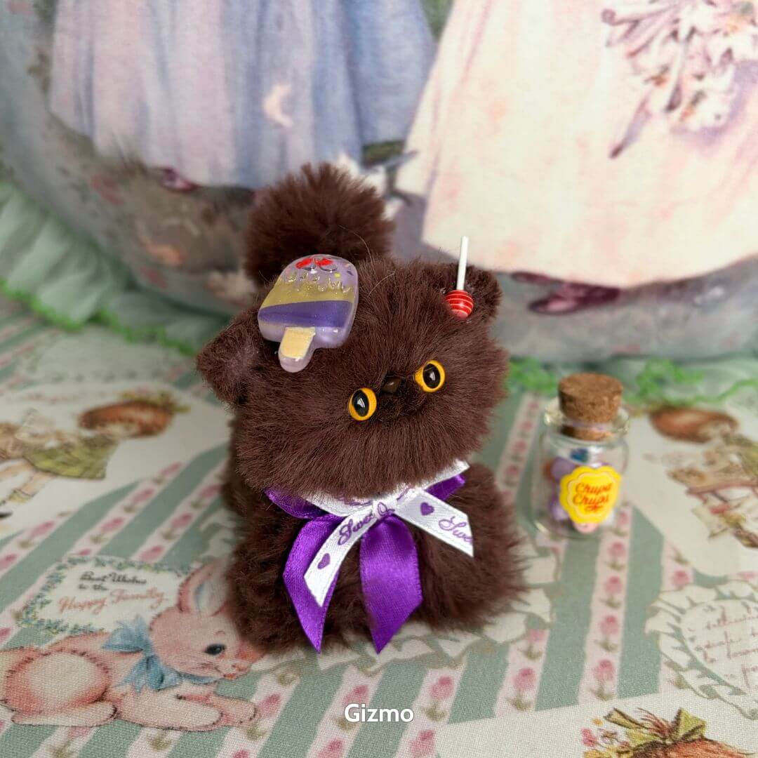 Adorable brown kitten figurine from the Brown Kitten Collection, wearing a purple ribbon and holding a mini dessert accessory.