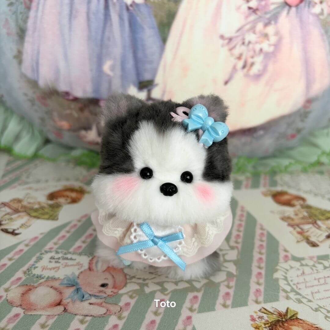 Handmade puppy from the Cosplay Puppy Collection, featuring fluffy fur, a pastel blue bow, and a sweet expression.