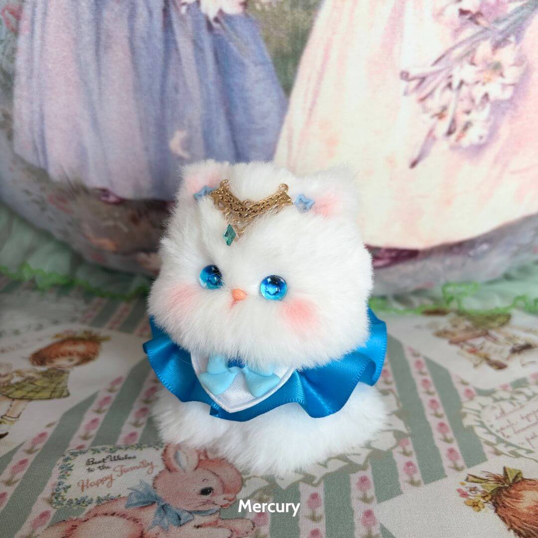 Moonbound Companions fluffy white handmade kitten with blue eyes, wearing a crown and ribbon, styled as a cute collectible.