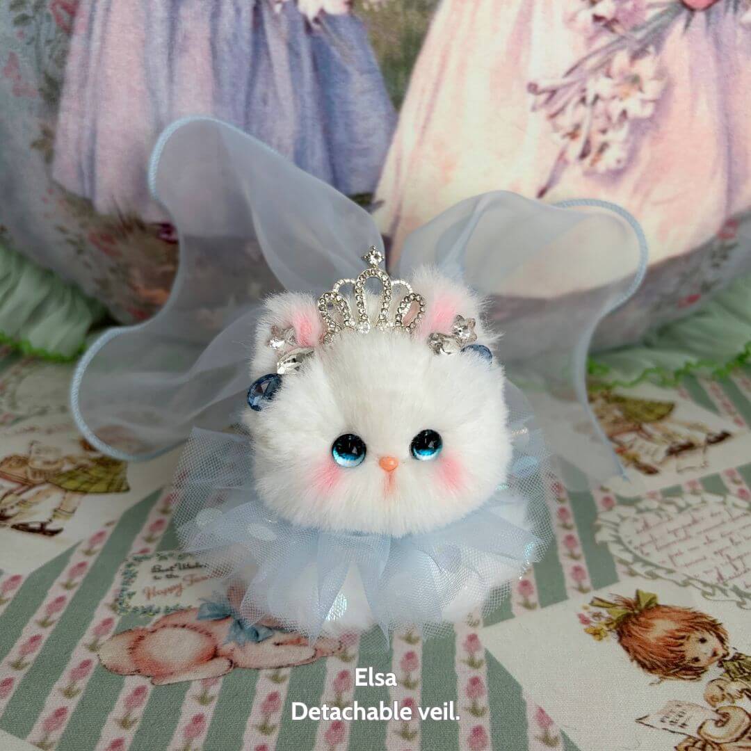Handmade kitten from Fairy Paws Collection, fluffy white with blue eyes, wearing a crown and translucent wings, cute animal collectible.