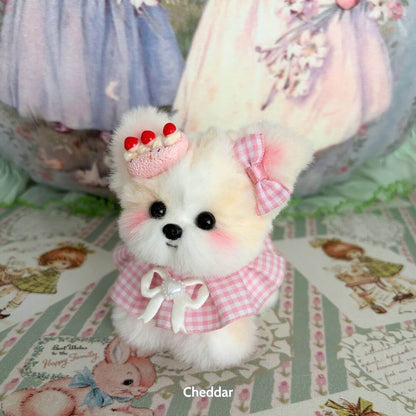 Adorable handmade puppy from the Cosplay Puppy Collection, fluffy with pastel colors, a pink bow, and a cute dessert hat.