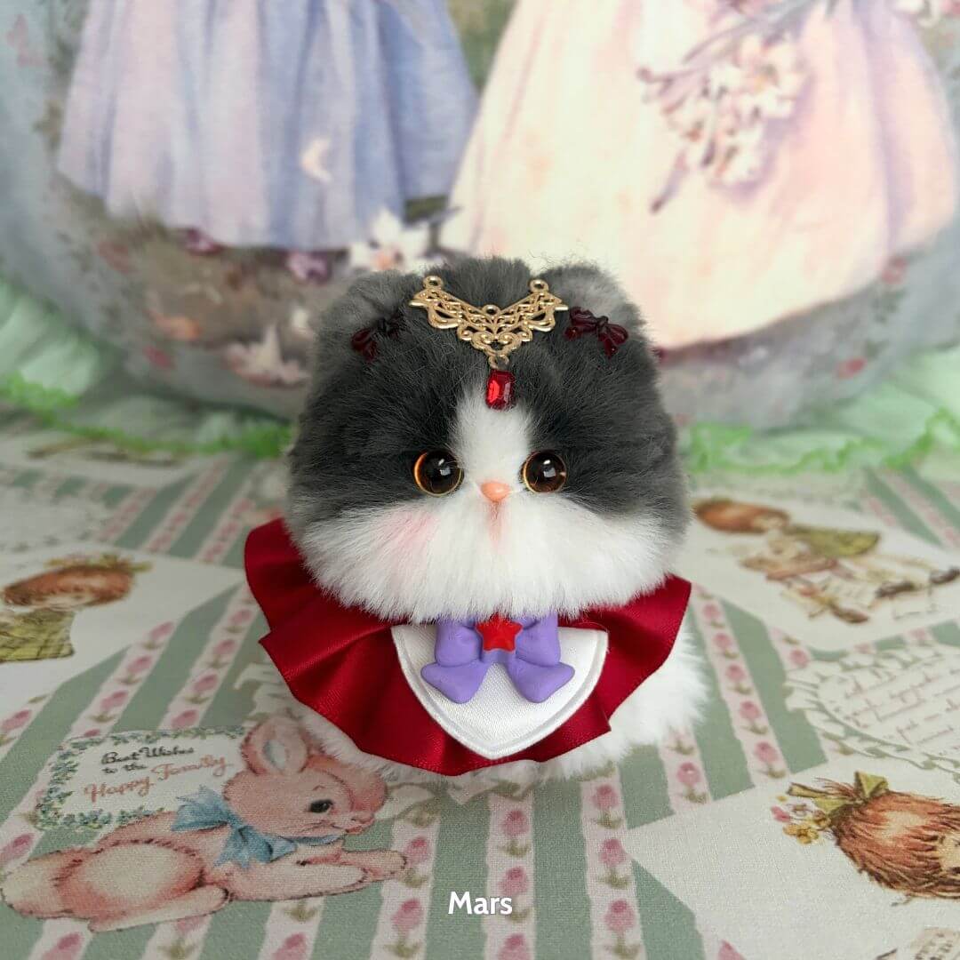 Alt Tag: Handmade kitten with grey and white fluffy fur, dressed in a red collar, set in a fantasy theme, Moonbound Companions.