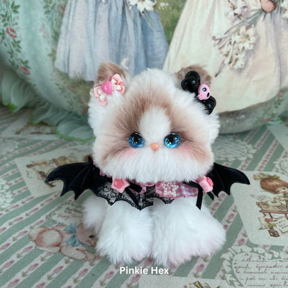 Handmade plush toy kitten from Enchanted Big Paws Collection with blue eyes, pink bow, and bat wings; unique gift for cat lovers.