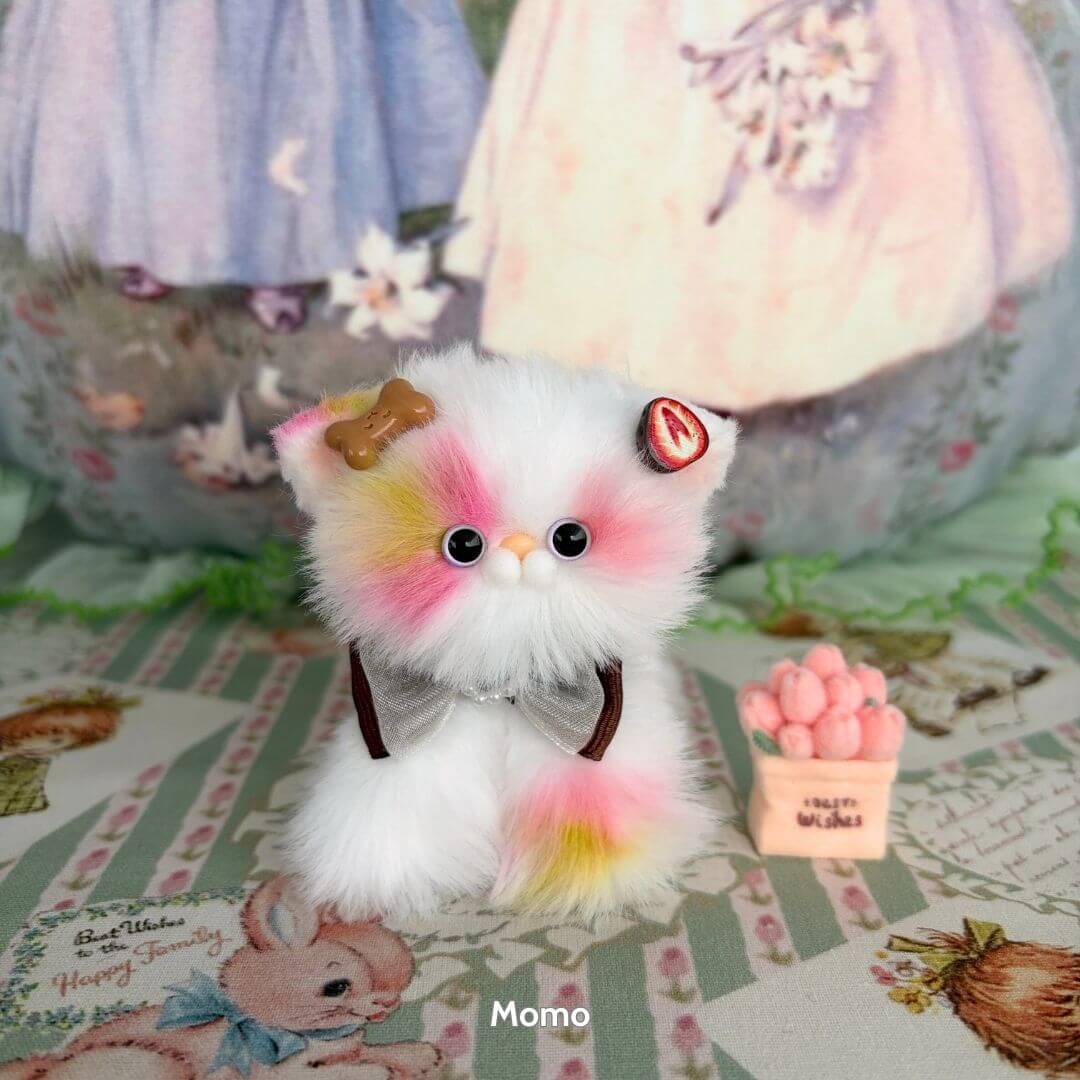 Sweet Dreams Kitten Collection: Fluffy white and pastel pink handmade kitten figurine with accessories, standing beside a tiny dessert decoration.