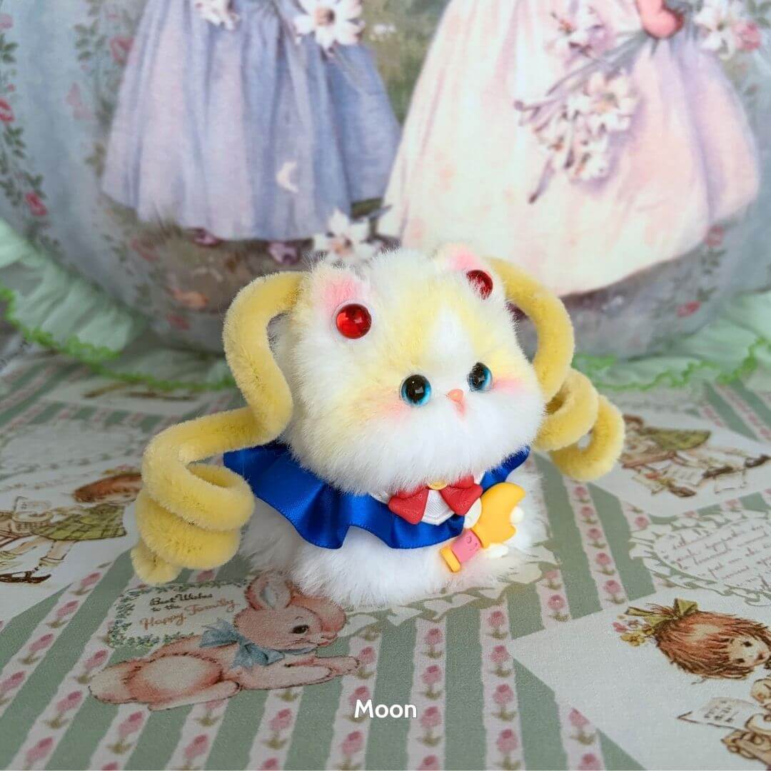 Handmade kitten figurine with fluffy yellow fur, blue bow, and red beads, themed Moonbound Companions.