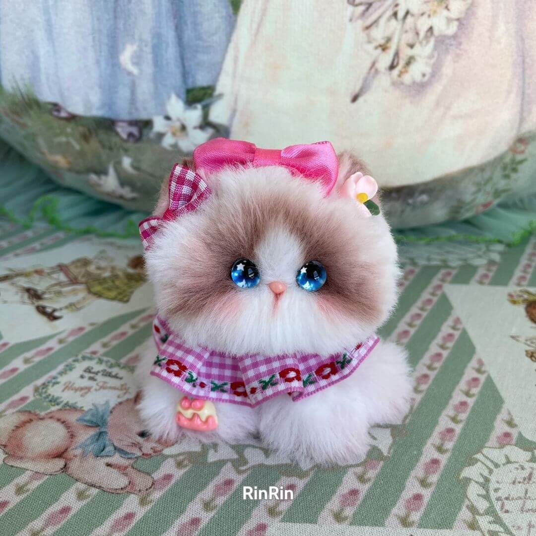 Handmade kitten with pink bow, blue eyes, and floral scarf; a cute animal collectible from the Cosplay Kitten Collection.