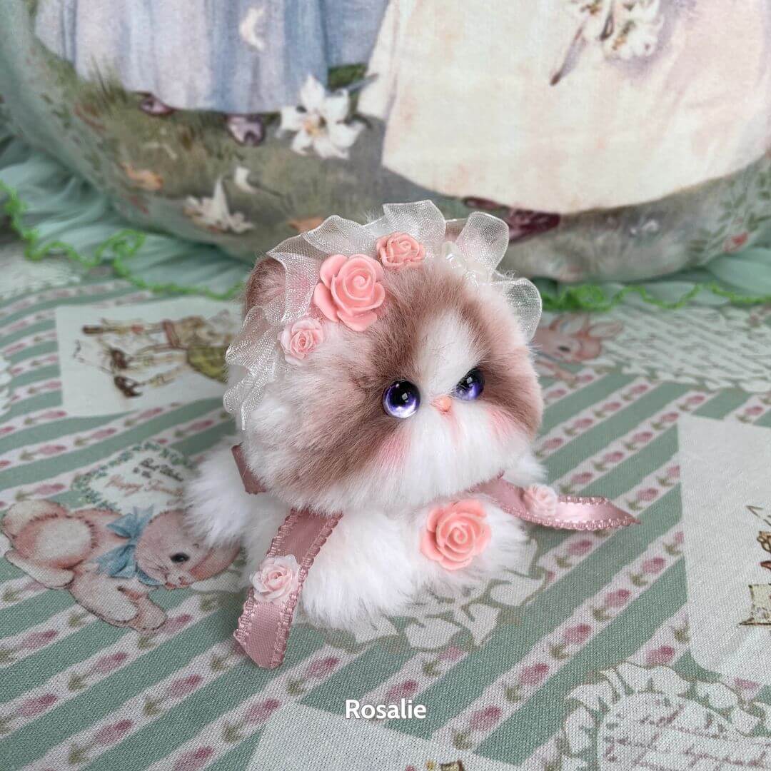 Adorable handmade kitten from the Blossom Kitten Collection, adorned with lace and roses, featuring fluffy fur and big eyes.