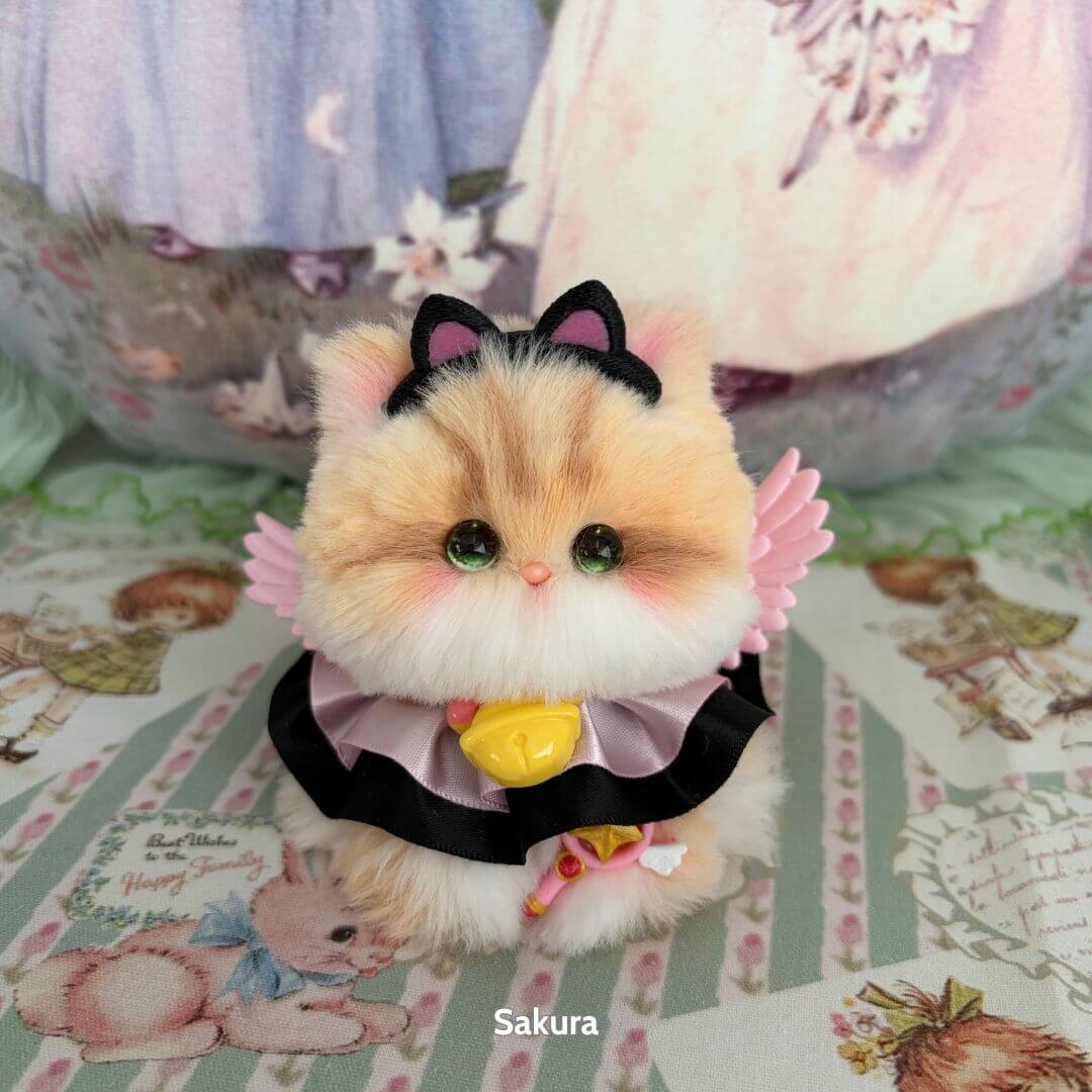 Alt Tag: Handmade kitten from Fairy Paws Collection, fluffy orange and cream cat figurine with pink wings and a black dress.
