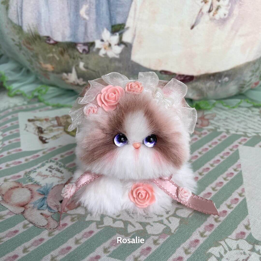 Adorable handmade kitten from the Blossom Kitten Collection, featuring a fluffy white and brown design, adorned with pink roses and lace.