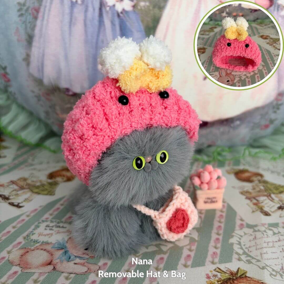 Fluffy Hoodie Kittens: grey handmade kitten wearing a pink hat with pom-poms and carrying a bag, cute kawaii style collectible figurine.