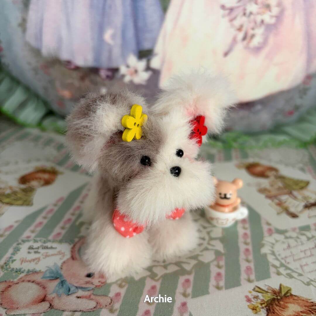 Adorable Puppy Collection, handmade fluffy dog figurine with colorful flowers, posing cutely on pastel background.