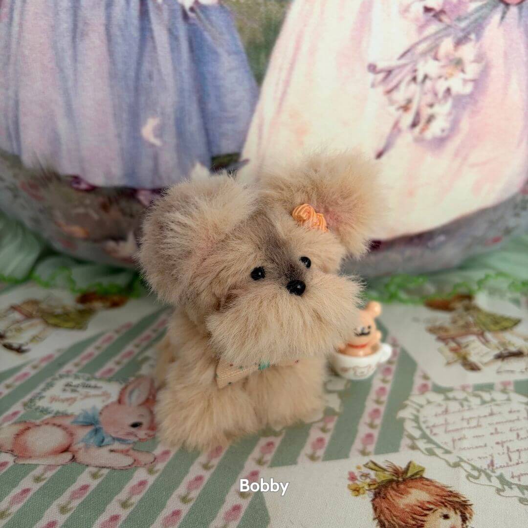 Adorable Puppy Collection featuring a fluffy light brown puppy with a bow, hand-sculpted and lifelike, on a pastel-themed background.