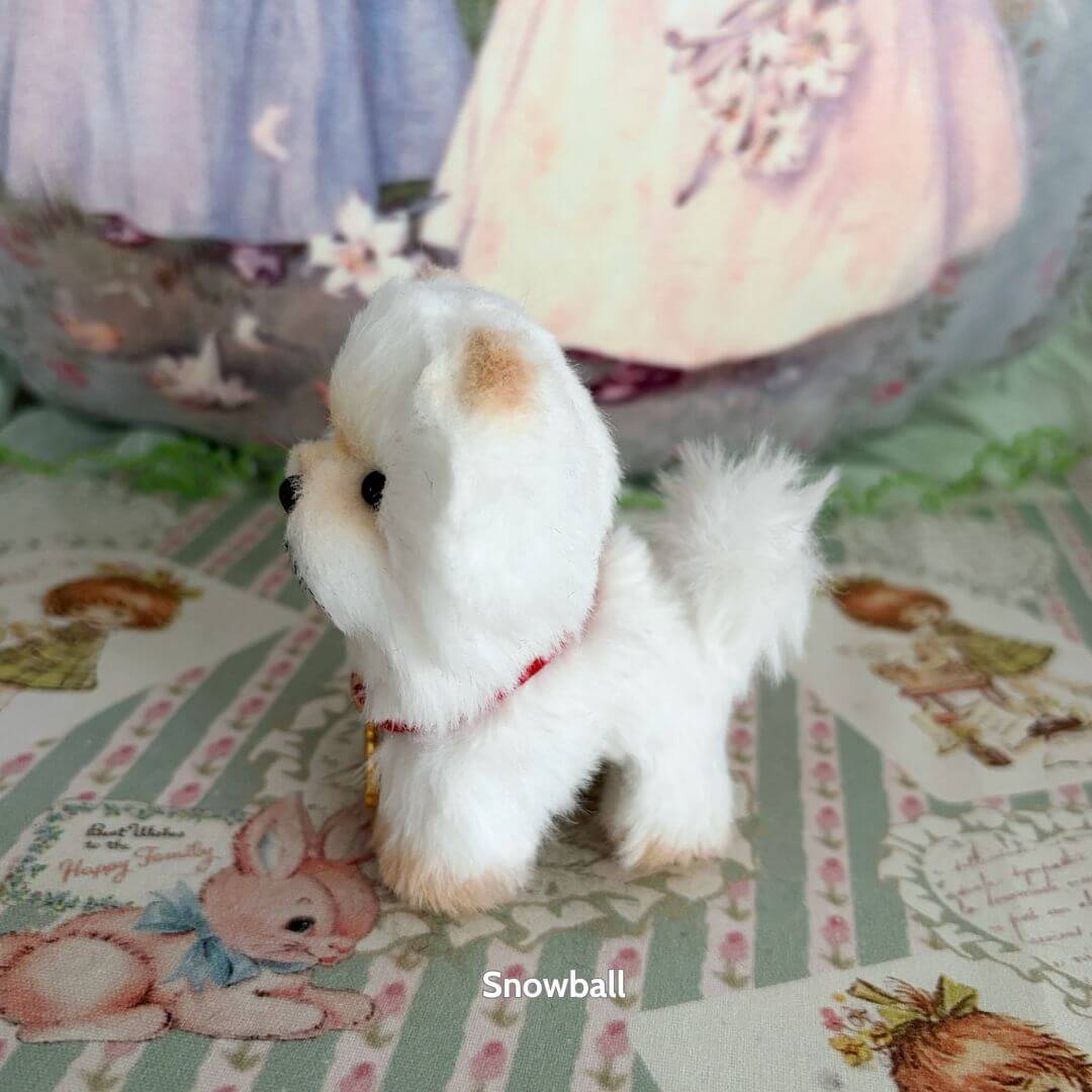 Lifelike Puppy Collection: fluffy white handmade puppy figurine with a red collar, posing cutely on pastel patterned background.