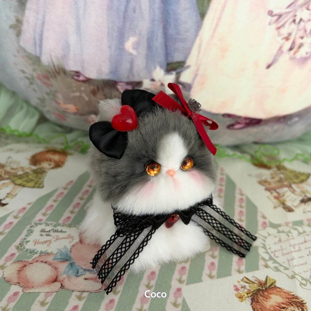 Handmade kitten from the Fairy Paws Collection, fluffy gray and white cat figurine with heart and bow accessories.