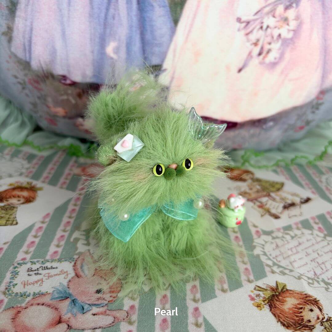 Handmade kitten from the Siberian Snuggles Collection, featuring fluffy green fur, cute expression, and whimsical accessories.
