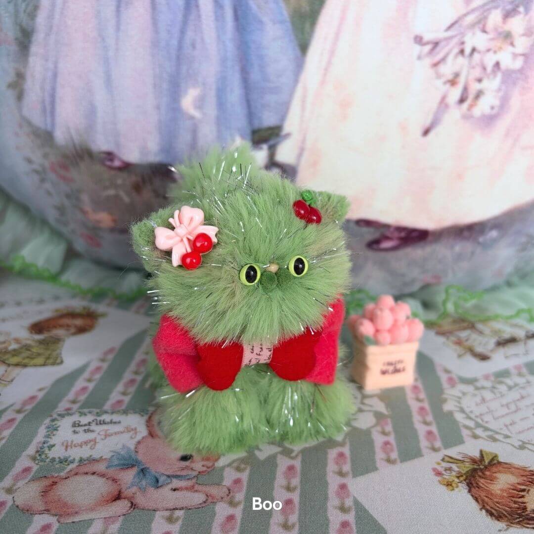 Twinkling Kitten Collection: cute green fluffy kitten with cherry accents, wearing red, handcrafted pet figurine with sparkle.