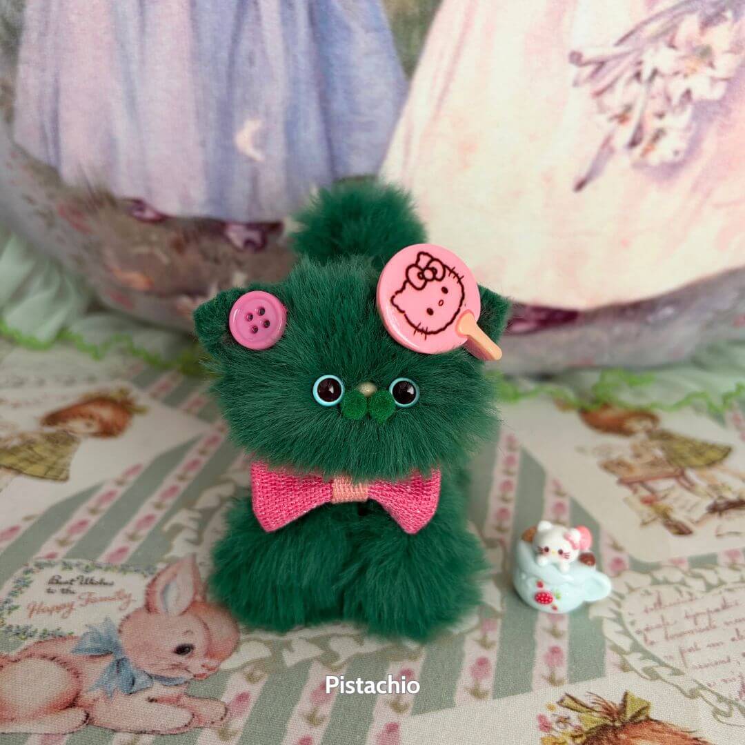 Handmade kitten from the Fruity Kitten Collection, fluffy green fur, pink bow, cute accessories, kawaii miniature cat.