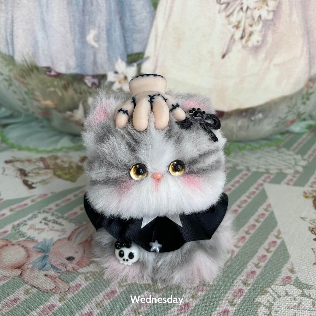 Cosplay Kitten Collection: fluffy grey kitten with a black bow, holding a spooky hand, cute handcrafted collectible.