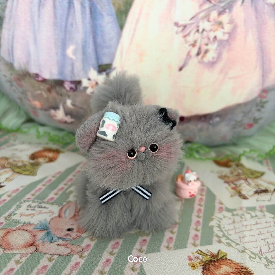 Fluffy grey kitten figurine from the Grey Kitten Collection, adorned with a blue bow and cute cup accessory, handmade in UK.