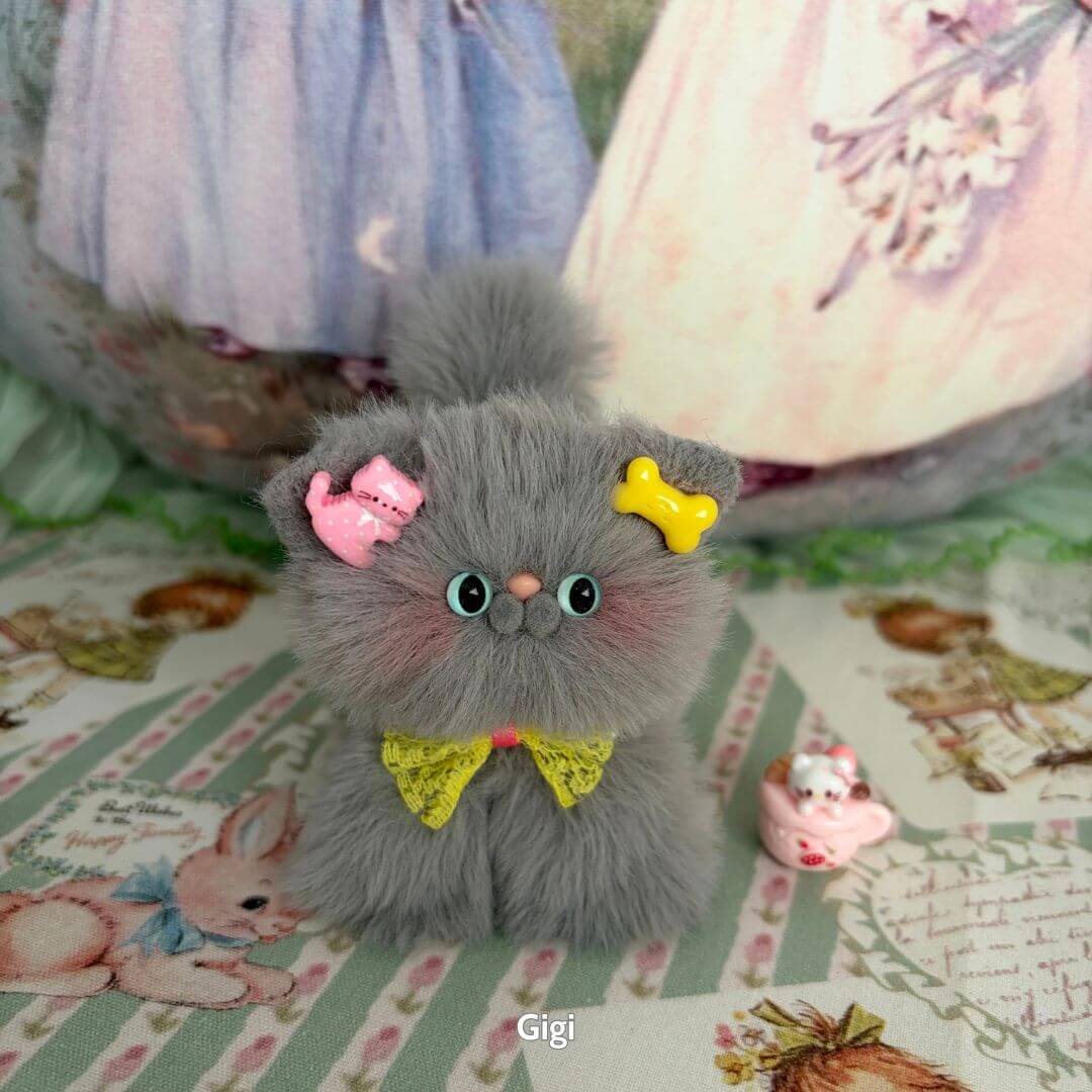 Adorable handmade kitten from the Grey Kitten Collection, featuring soft grey fur and cute accessories like a yellow bone and pink cats.