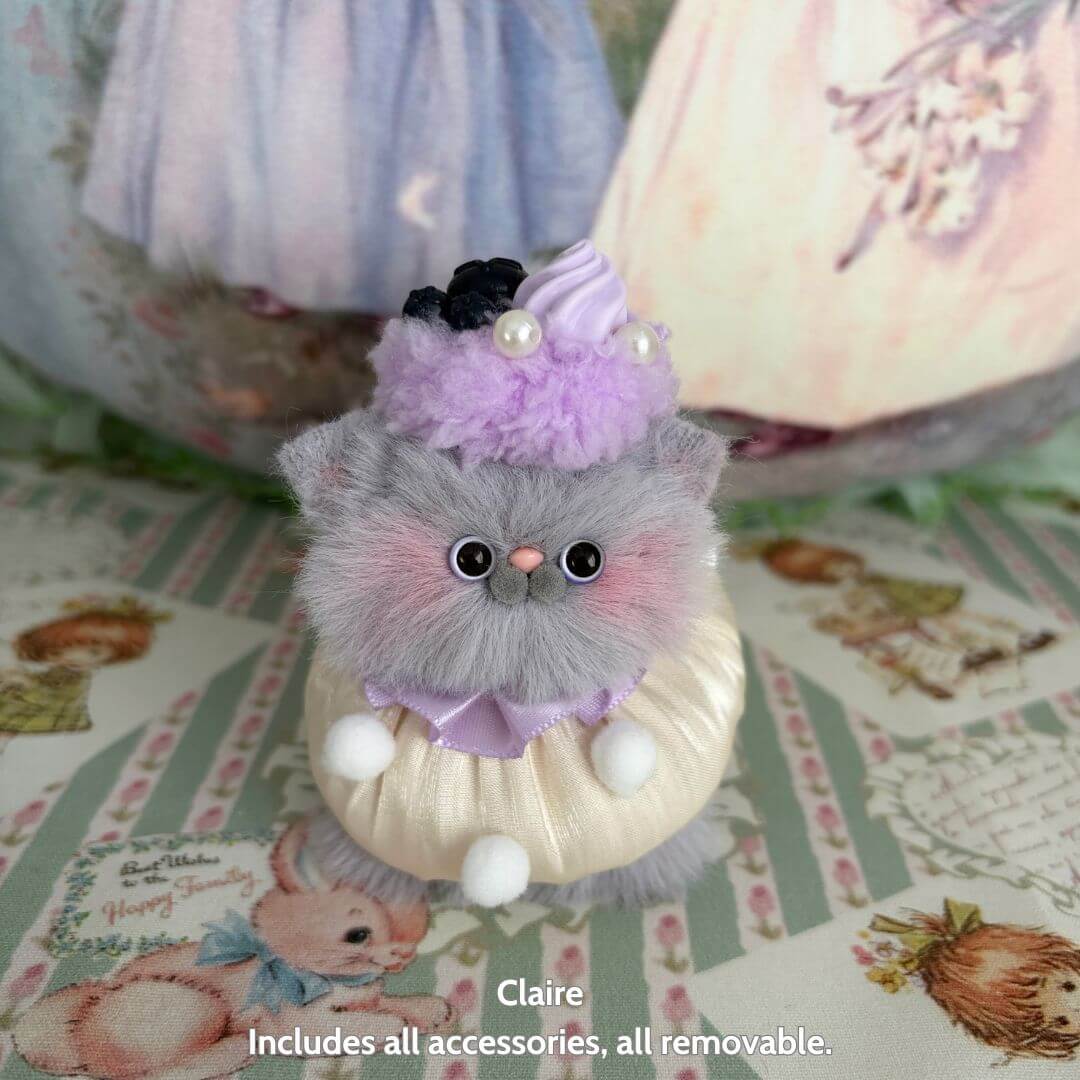 Sweet Treat Kitties miniature kitten in fluffy grey, wearing a purple dessert hat, cute animal collectible, handmade in UK.