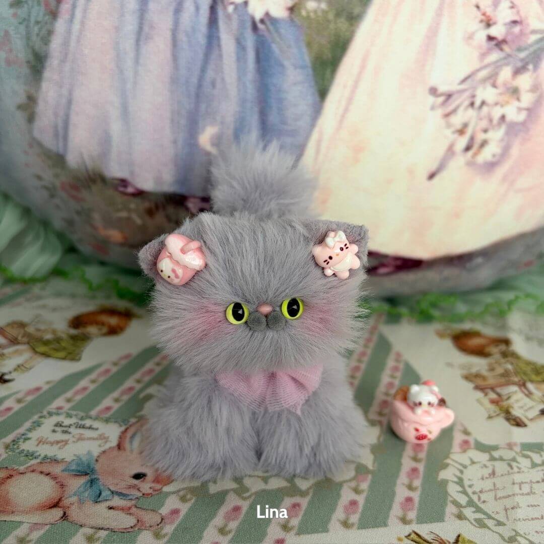 Handmade kitten from the Grey Kitten Collection, a fluffy grey cat figurine with playful pig accessories and pink bow.