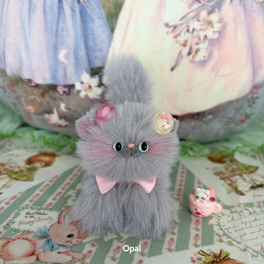 Cute handmade kitten from the Grey Kitten Collection, featuring fluffy grey fur, a pink bow, and whimsical cupcake accessory.