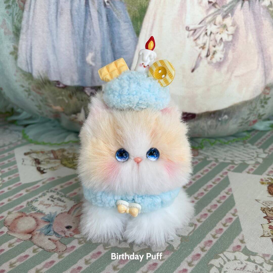 Alt Tag: Handmade kitten in pastel colors with blue birthday hat and candle, part of the Mewlicious Collection, cute animal collectible.
