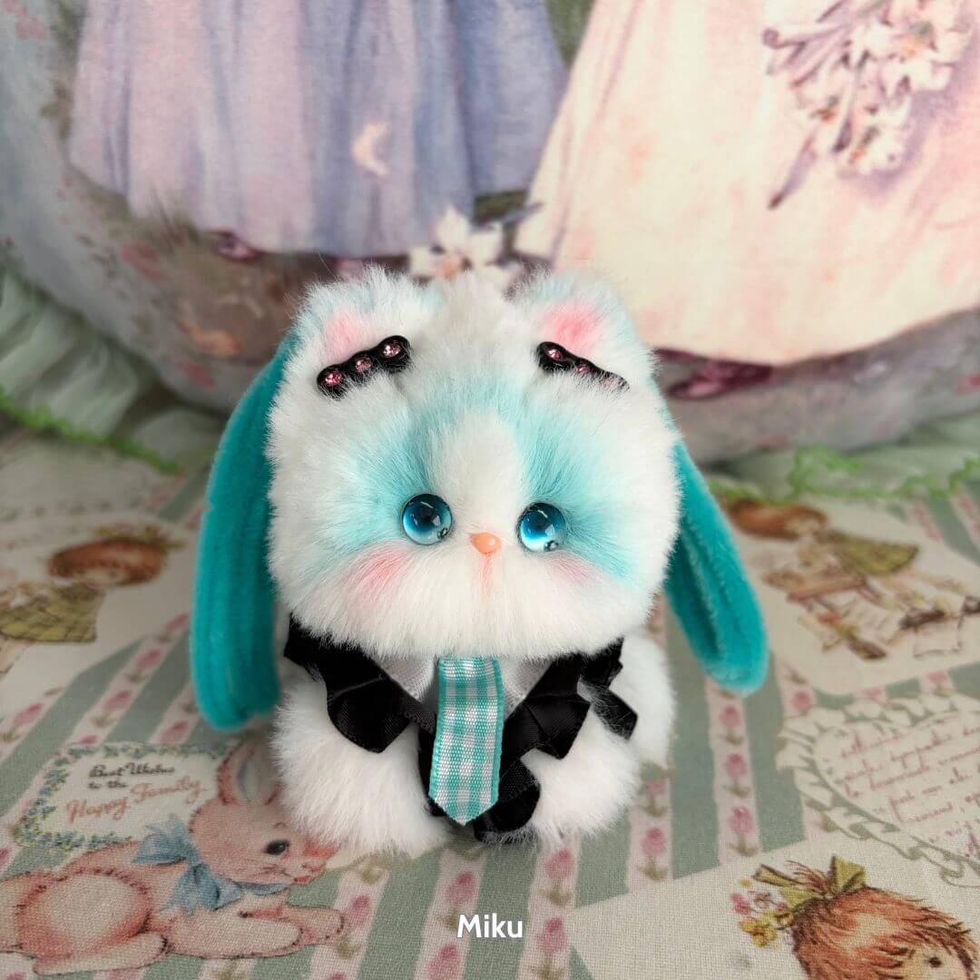 Handmade kitten from the Cosplay Kitten Collection, featuring fluffy blue and white fur, cute bow accessories, and playful pose.