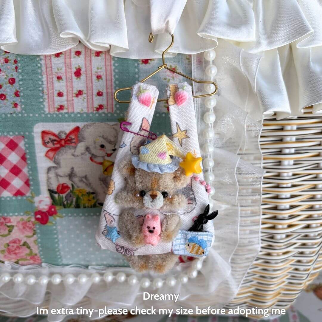 Alt Tag: Cute handmade bear figurine in pastel colors, wearing a party hat, hanging from a tiny hanger as part of Little Hanger Pals.