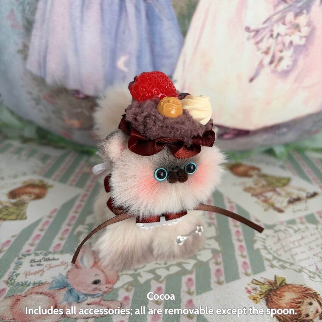 Sweet Treat Kitties handmade kitten with a dessert-inspired hat, fluffy fur, and cute features, in pastel colors.