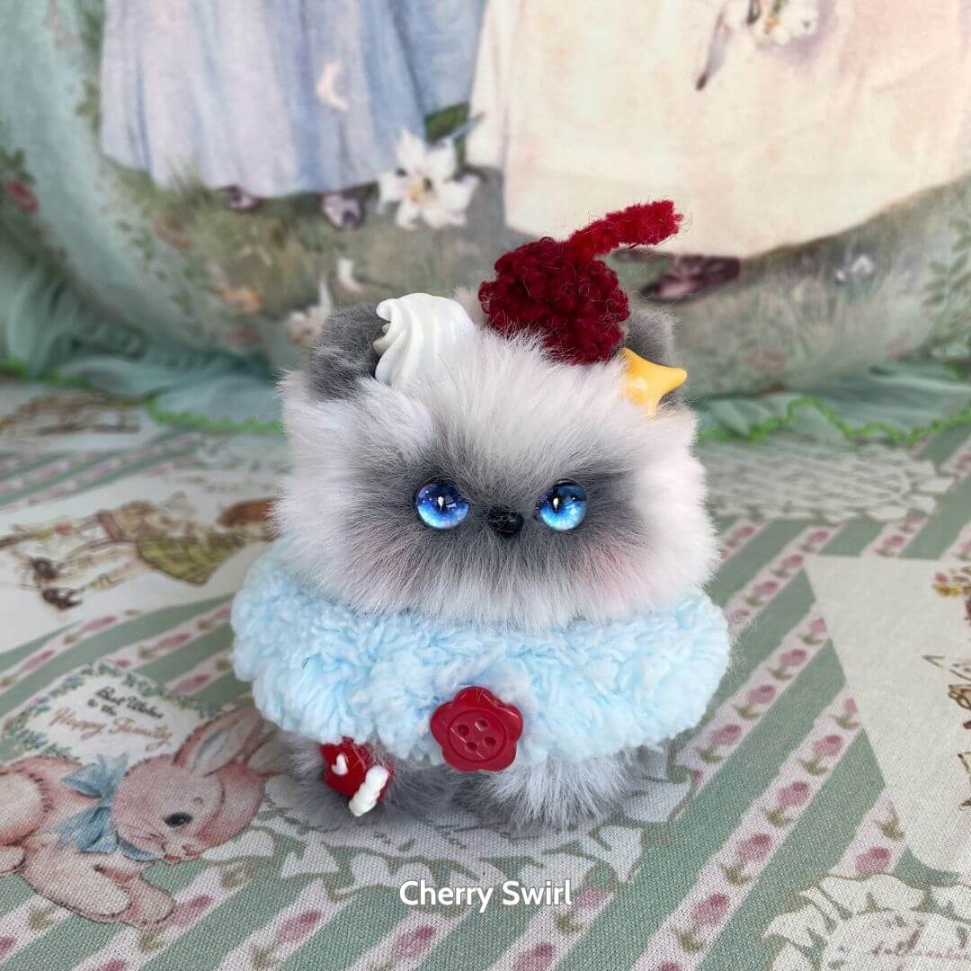 Handmade kitten from the Mewlicious Collection, fluffy gray and white cat figurine dressed as dessert with cherry on top.