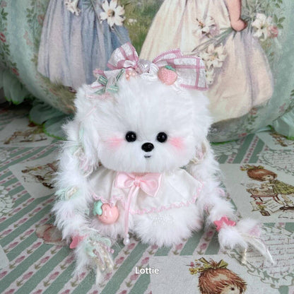 Adorable fluffy kitten from the Enchanted Big Paws Collection, dressed in pink and white with bows and playful accessories.