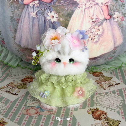 Adorable fluffy kitten figurine from the Enchanted Big Paws Collection, wearing a flower crown and a green ruffled dress.