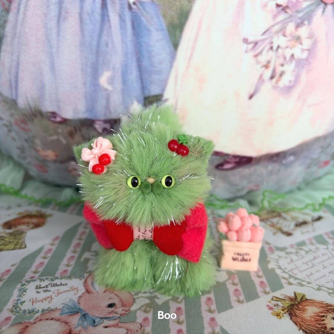 Cute fluffy kitten figurine in green with red accents, handmade in UK. Part of the Twinkling Kitten Collection, showcasing kawaii style.