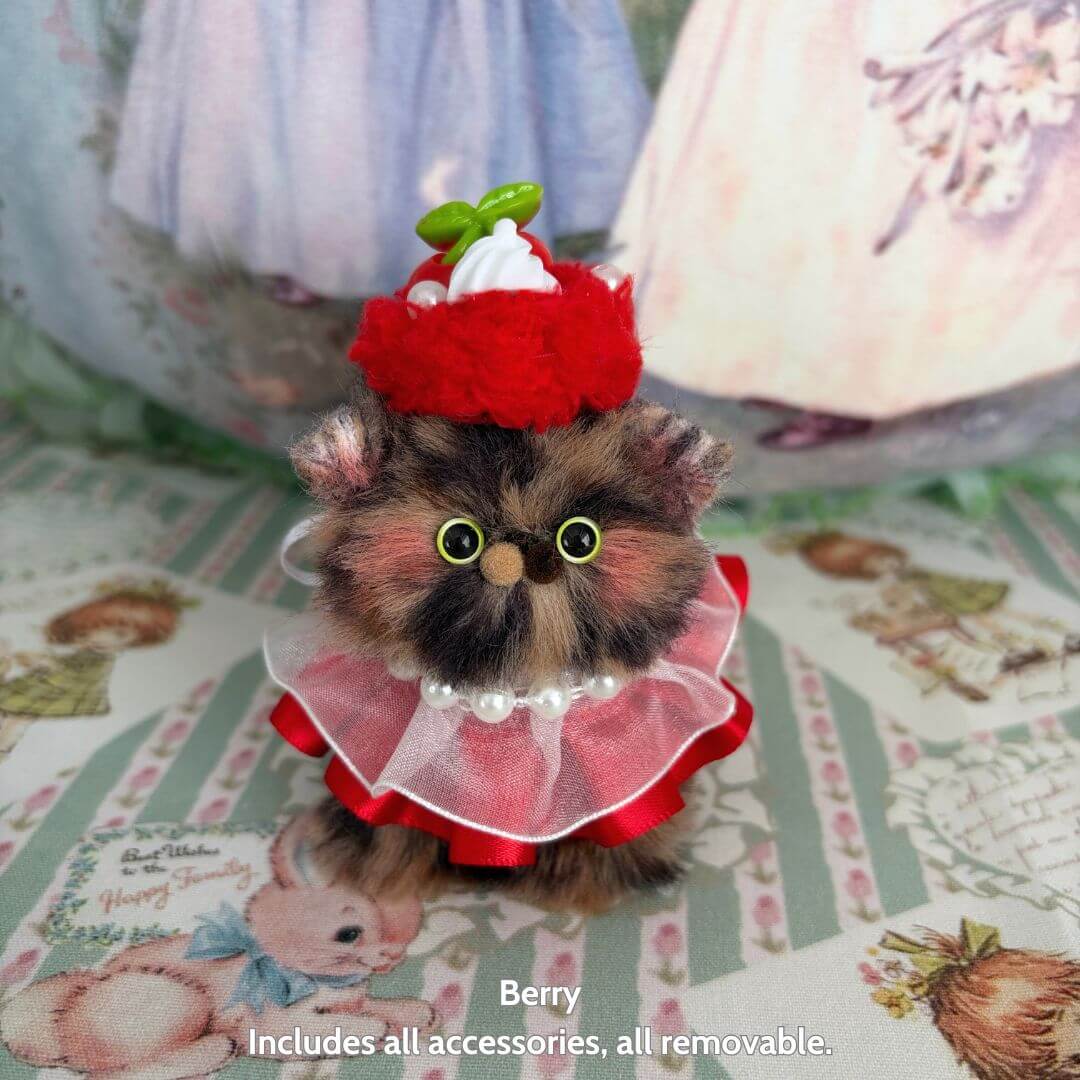 Sweet Treat Kitties miniature kitten wearing a red dessert hat and pearl collar, fluffy kawaii cat figurine in pastel decor.