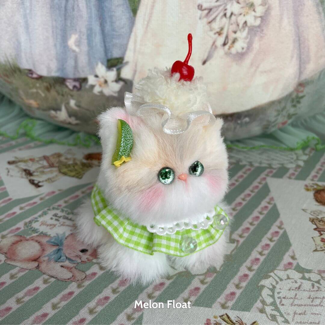 Cute fluffy kitten from the Mewlicious Collection dressed as a melon float, with a cherry on top, handmade in the UK.