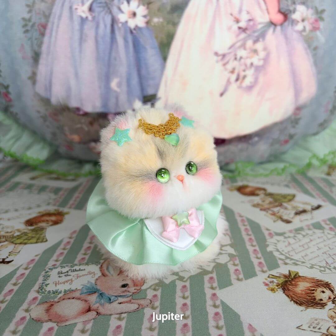 Cute handmade kitten, Moonbound Companions, fluffy cat figurine with pastel colors, star accessories, adorable pose.