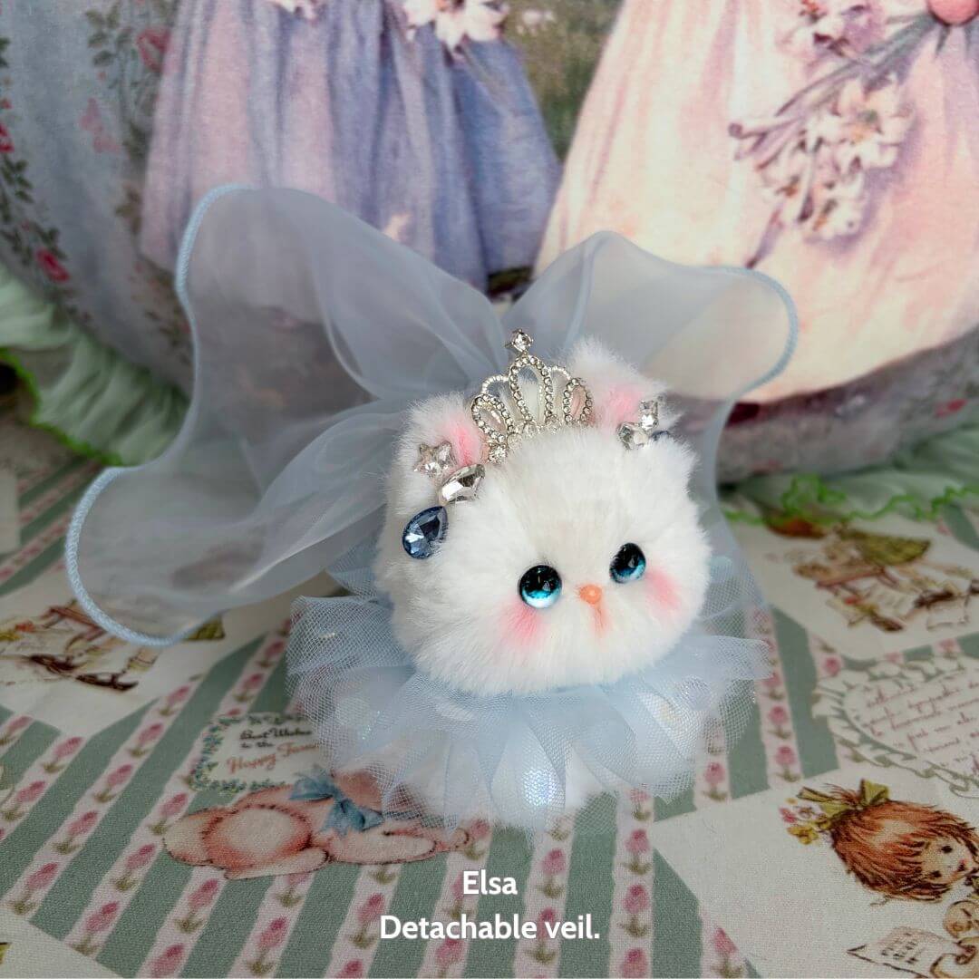 Handmade kitten from the Fairy Paws Collection wearing a detachable veil, with blue eyes and a fluffy white fur coat.