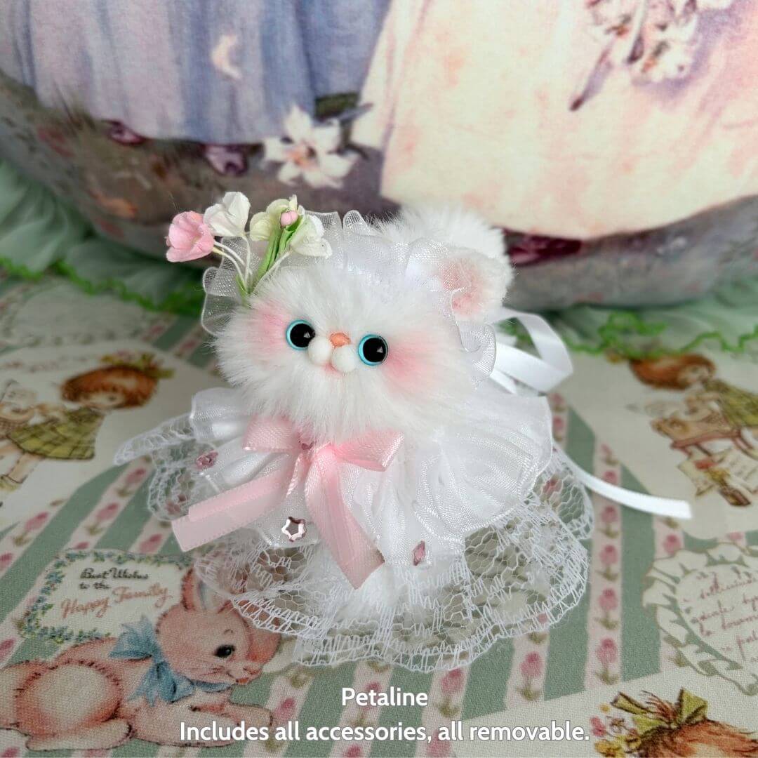 Handmade kitten from Petals & Whispers Collection, fluffy and cute, dressed in lace with a flower accessory, pastel colors.