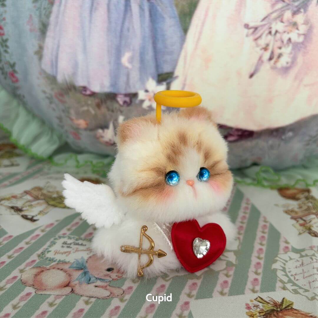 Handmade kitten from the Fairy Paws Collection, fluffy and cute with blue eyes, adorned with angel wings, heart and golden halo.